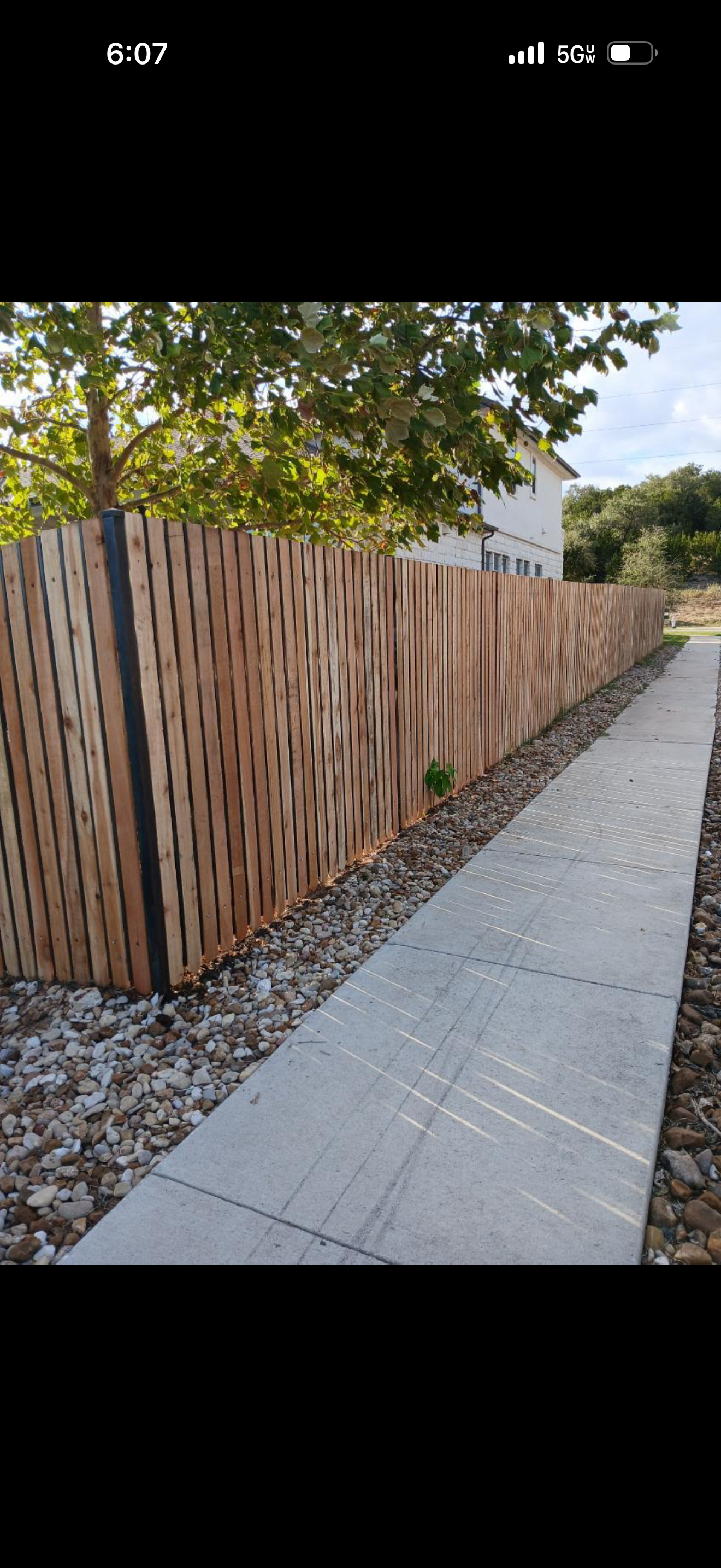 Stone tree planter with cedar fence backdrop — Ancfence LLC